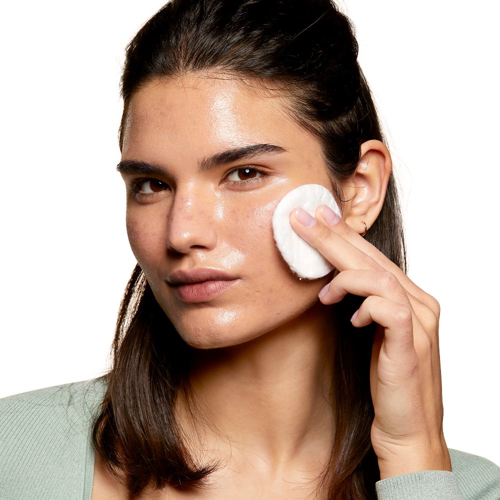一名女性正用化妆棉清洁面部