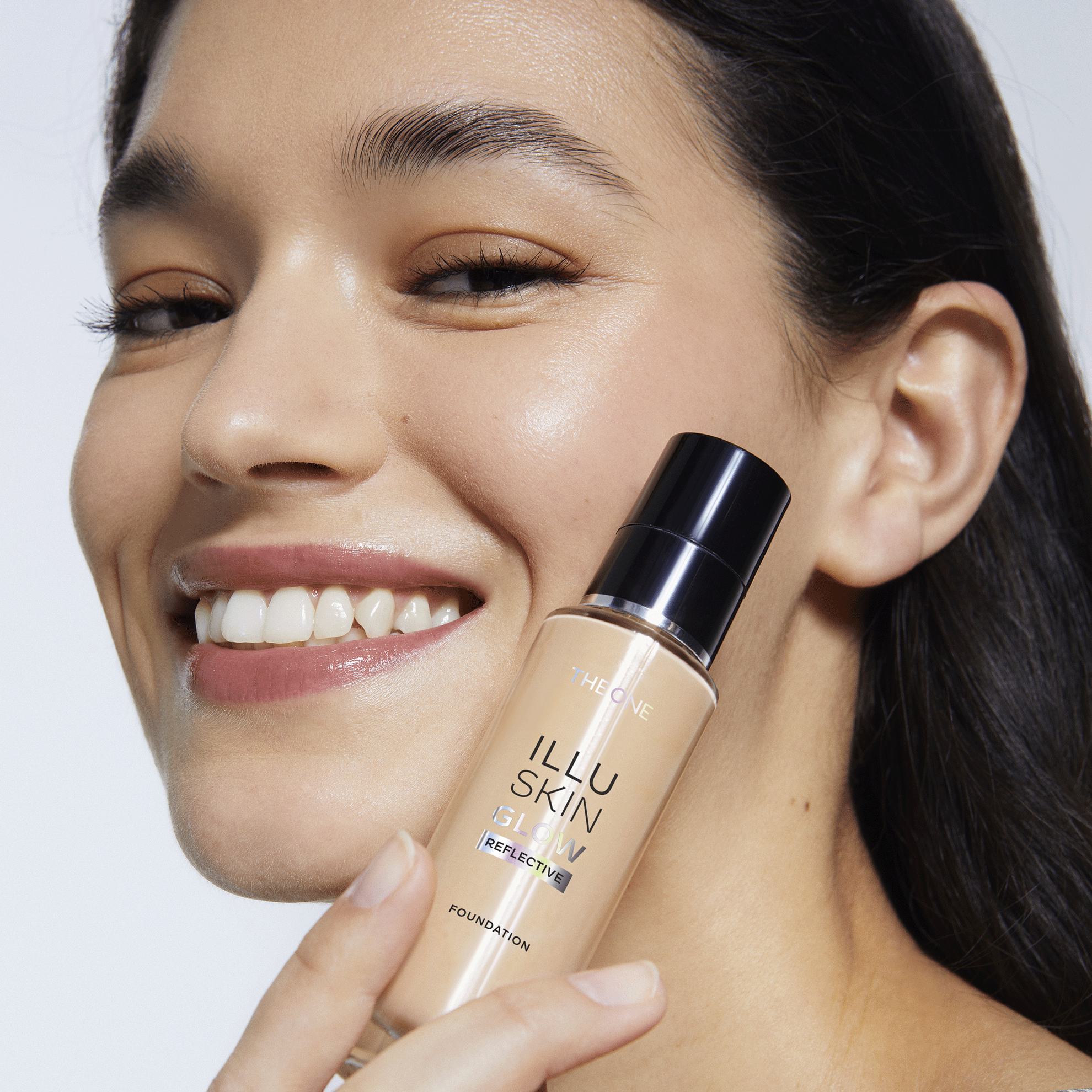 一名女子手持一瓶粉底液