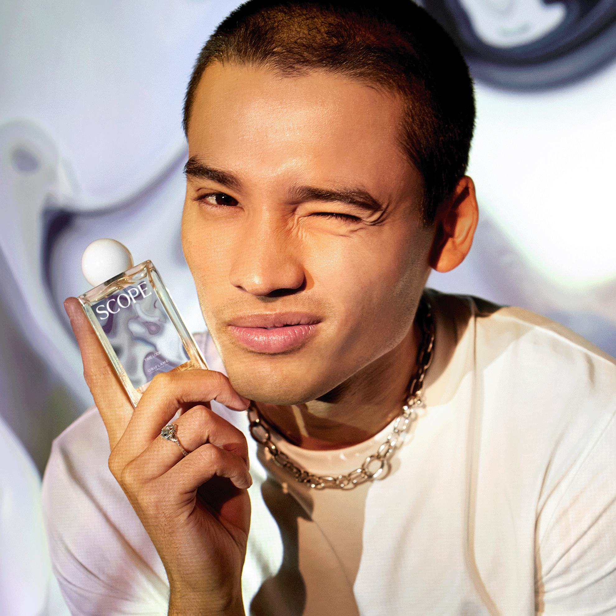 一名男子手持香水瓶